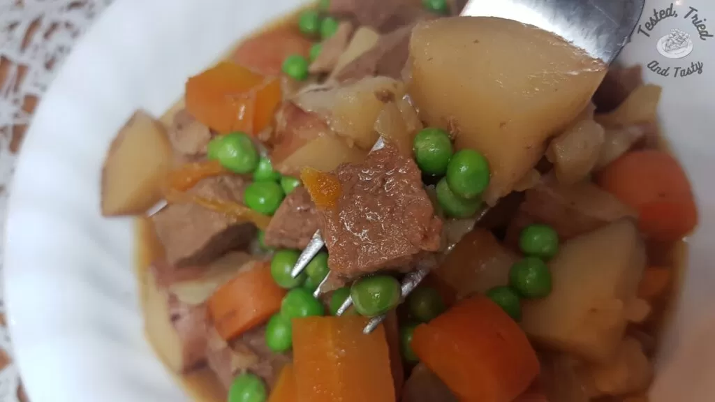 slow cooker beef stew in a white bowl.