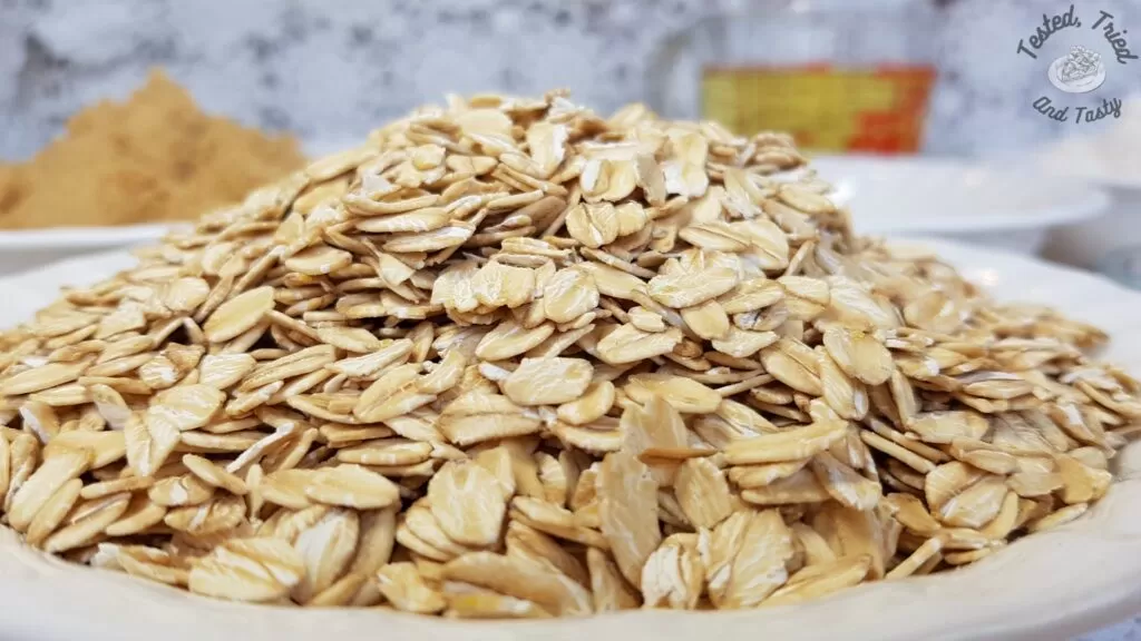 Old fashioned rolled oats in a white bowl.