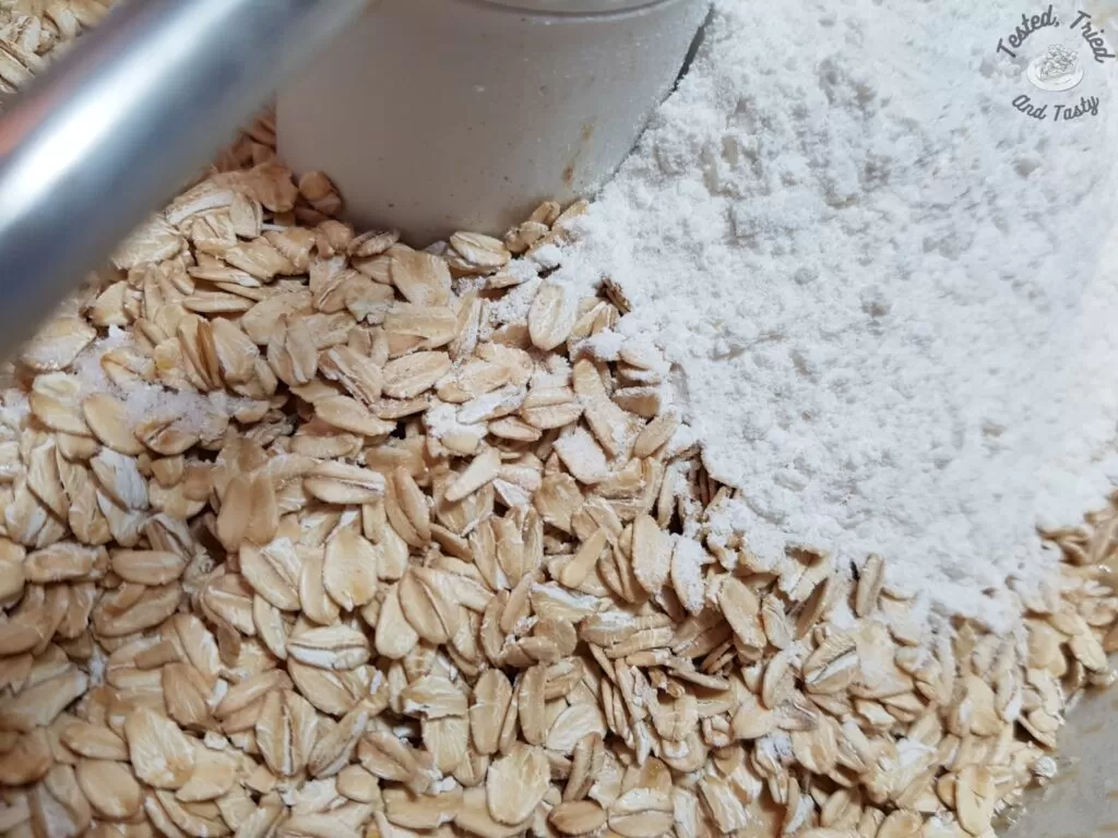 Adding the flour and rolled oats to the liquid ingredients.