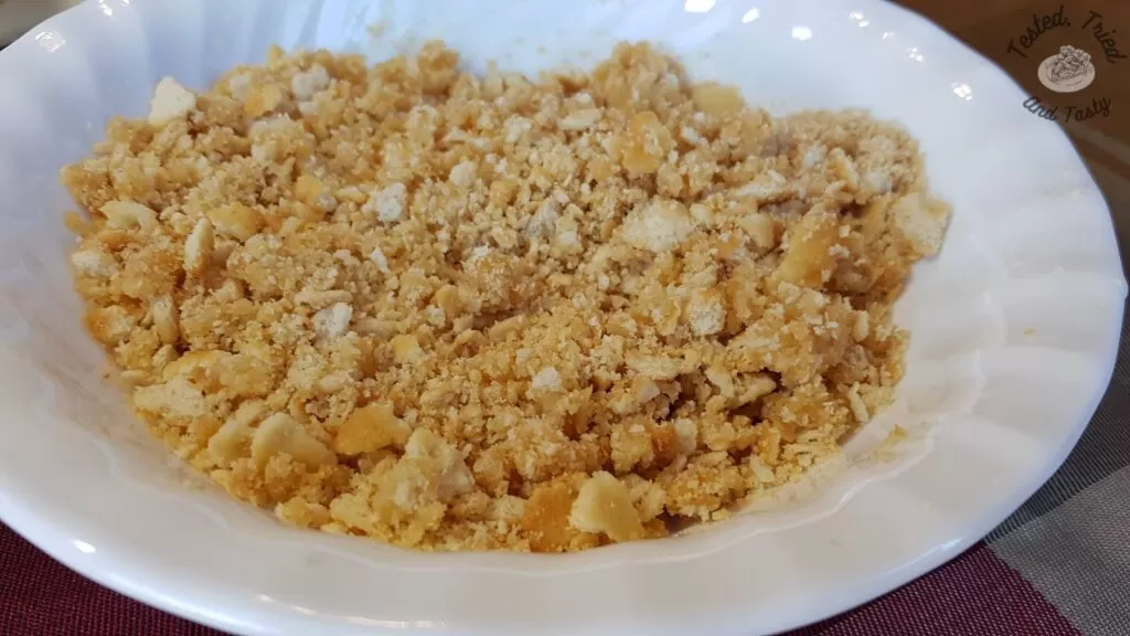 Crushed ritz crackers in a white bowl.