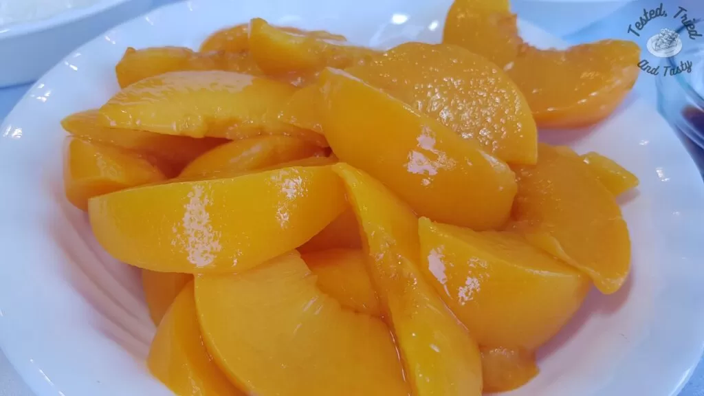 Sliced peaches in a white bowl.