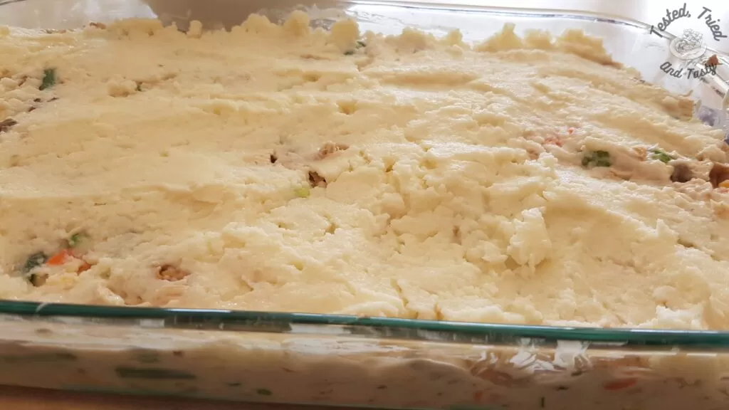 Mashed potatoes on top of the turkey and gravy mixture.